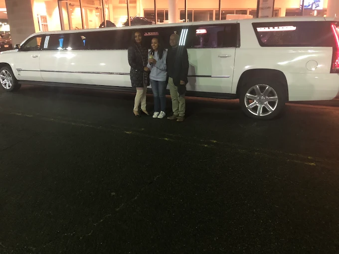 Cadillac Escalade stretch limousine with chauffeur at night